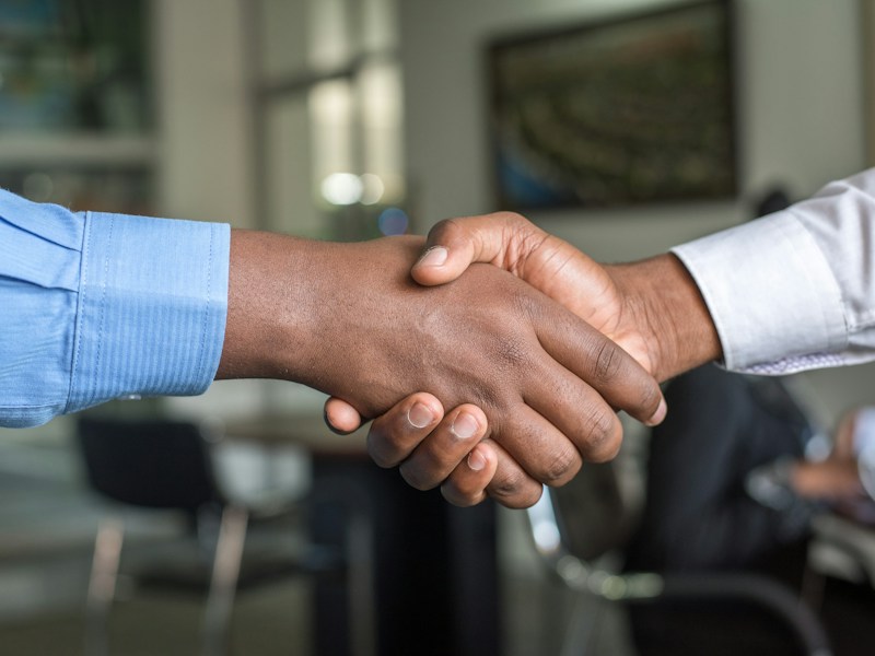 Close-up of a business handshake between two colleagues in an office